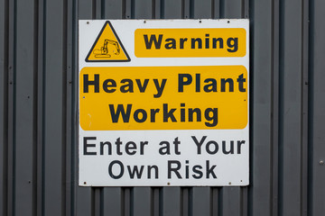 Heavy plant working warning sign on an industrial unit