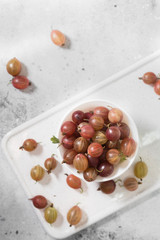 Gooseberries in a white bowl on a light background