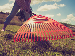 Unusual angle of woman raking leaves