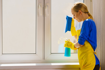 Woman cleaning window at home