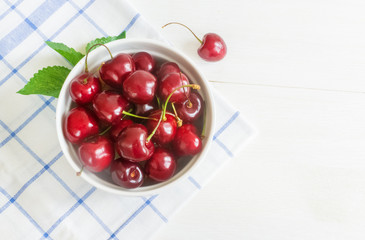 Naklejka na ściany i meble Fresh cherry on plate on wooden white background. fresh ripe cherries. sweet cherries.