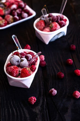 Homemade fresh yogurt. Healthy sweet dessert on dark rustic wood. Frozen fruits