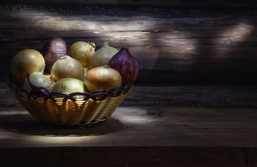 onion in basket on wooden background