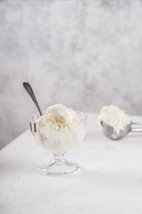 Vanilla ice cream in a glass bowl. Scoop of ice cream on background.