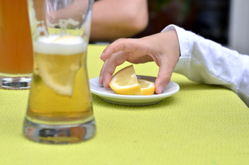 Hand greift nach Zitronenscheiben auf einem weißen Teller