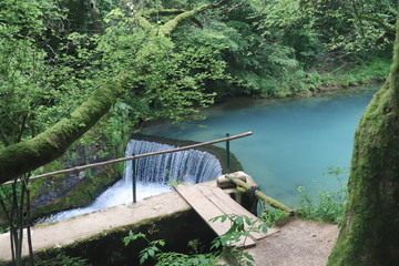 Amazingly beautiful mountain's spring with heavenly blue water color and small waterfall named Krupajsko Vrelo (spring of Krupaj), near Krupaja village, Eastern Serbia 