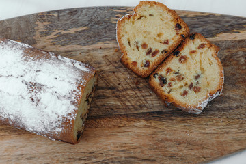 Raisin cake, dusted with icing sugar. Cupcake with raisins on a wooden board