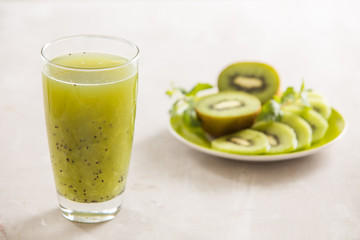 Glass of kiwi juice with fresh fruits on wooden table