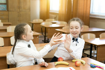 Schoolgirl treats her friend a meat sandwich. The girl gives her friend vegetarian treats her...