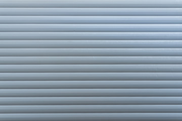 Obraz premium White metal with horizontal linear stripe pattern of rolling shutter door.
