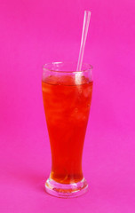 Glass of iced tea on pink background
