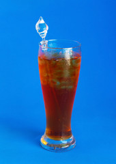 Glass of iced tea on blue background