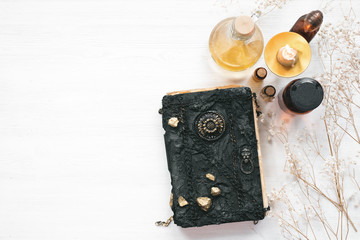 Magic recipe book of witch doctor, dried herbs and a magic potion on a wooden table. Witchcraft background. Druidism.