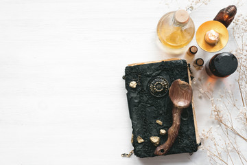 Magic recipe book of witch doctor, dried herbs and a magic potion on a wooden table. Witchcraft...