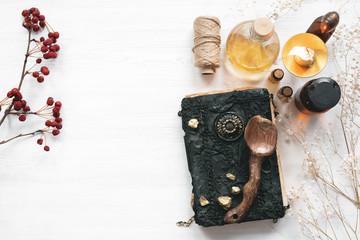 Magic recipe book of witch doctor, dried herbs and a magic potion on a wooden table. Witchcraft...