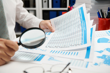 Businessman working and calculating, reads and writes reports. Office employee, table closeup. Business financial accounting concept.