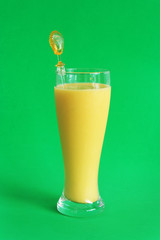 Mango smoothie on green background