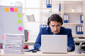 Young male employee unhappy with excessive work 