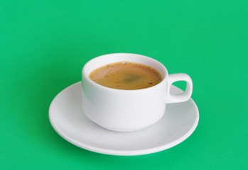 White coffee cup on green background