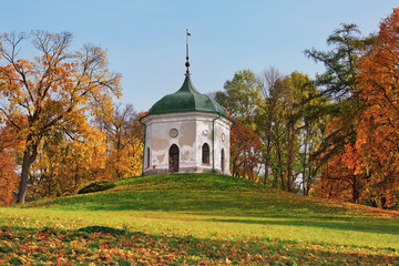 Chapel in the park surrounded by carpet of colored fallen leaves