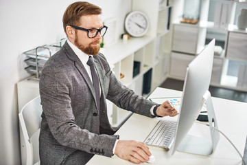 Mid age businessman working on computer at the office