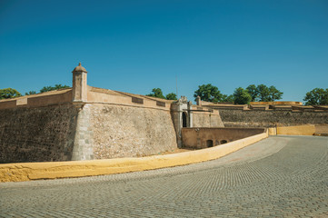 Fototapeta na wymiar Street at the city wall with an entrance and small bridge