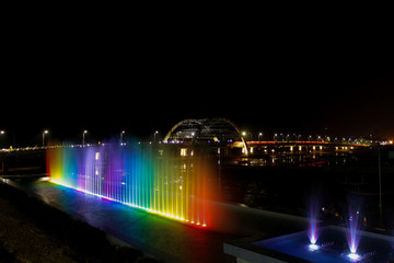 Obraz na płótnie Canvas rainbow water fountain and bridge at night