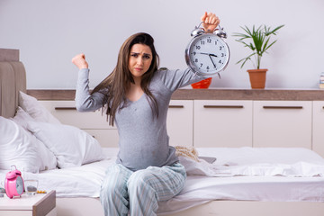 Young pregnant woman in the bedroom 