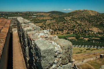 Pathway over stone wall and a fortress on top of hill