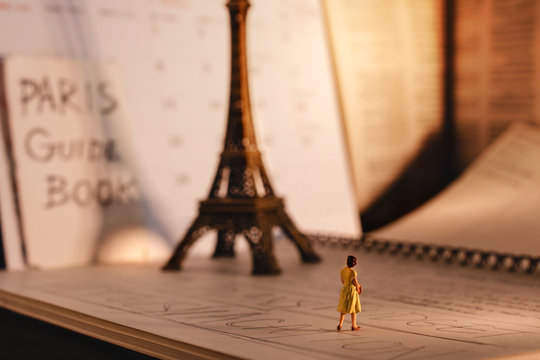 Dream Destination for Vacation. Travel in Paris, France. a Miniature Tourist Woman Looking at the Eiffel Tower and Calendar. Warm Tone. Vintage Style