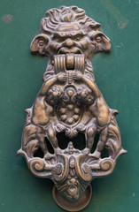 An old style decorative bronze door handle on a wooden green door, the distinctive feature and symbol of Malta in Mdina.