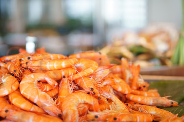 steamed banana shrimp or banana prawn orange serve on wood tray and banana leaf for lunch or dinner on seafood buffet restaurant at hotel with warm light on delicious food with space