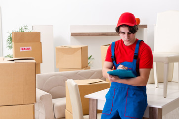 Young male contractor with boxes working indoors 