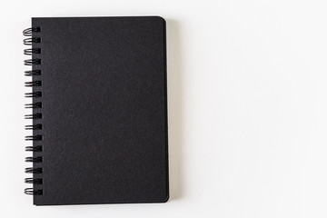 Open notebook with black pages on a spiral on a light background. Place for text. The concept of learning, sketch, writing. Flat lay, minimalism, top view, design.