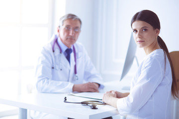 Two doctors smiling in consulting room in hospital