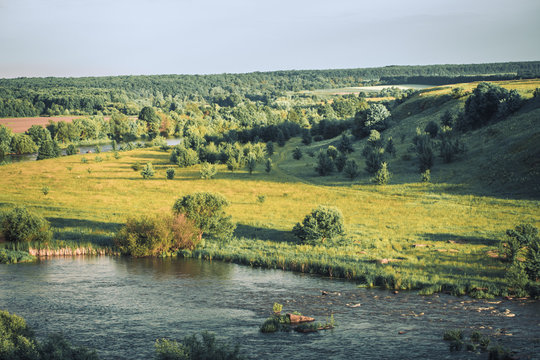 The view on Optina Pustyn Orthodox monastery for men near Kozelsk in Russia in summer sunny day among green fields. river, fores, blue sky