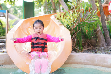Asian child cute or kid girl swimming wear life jacket and smiling enjoy with happy fun playing...