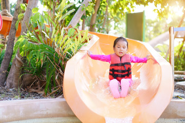 Asian child cute or kid girl swimming wear life jacket and smile enjoy with happy fun playing...
