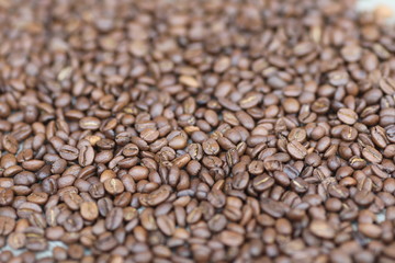 Coffe beans in hands and on the wooden  table, roasted arabica
