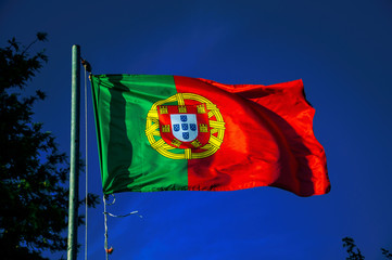 Portuguese flag fluttering in the blue sky