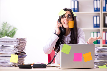 Young female employee in conflicting priorities concept 