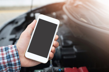 close up young business man hand using a mobile smart phone call a car mechanic ask for help assistance because car broken on the roadside. blank if empty screen.