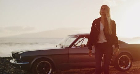 Beautiful woman walking away from a vintage car