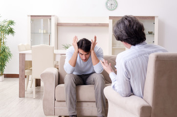 Young male patient discussing with psychologist personal problem