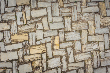 white pink gray broken pieces of ceramic tile in cement. rough surface texture mosaic and moss in...