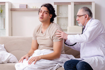 Old male doctor visiting young male patient  