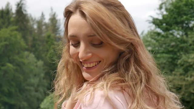 Beautiful smiling girl with long curly hair outdoor. Happy holidays, travel concept