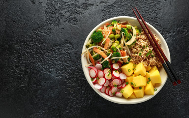Asian style Vegan salad bowl with edamame, vegetable stir-fry mix, wholegrain rice, quinoa, mango chunks drizzled with mango, chilli dressing