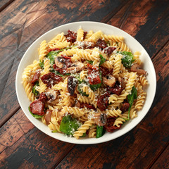 Fusilli Pasta with sun dried tomatoes, mushrooms, parmesan cheese and spinach. healthy food.