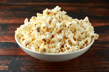 bowl of salty popcorn on wooden table